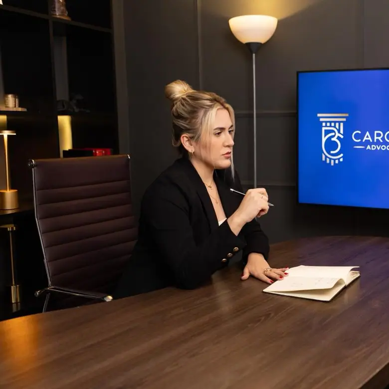 Dra. Caroline Bandeira na sala de reuniões do escritório, com o logo na tela ao fundo