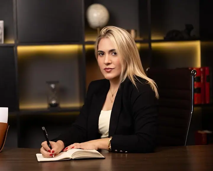Dra. Caroline Bandeira à mesa, fazendo anotações em um caderno